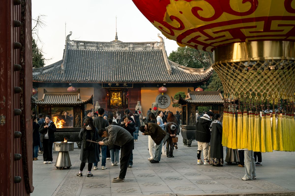 Visitors making incense offerings in a Shanghai temple courtyard