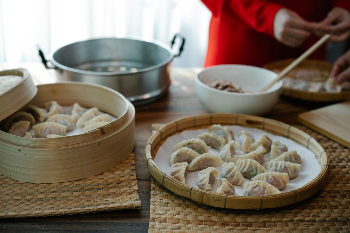 Fresh jiaozi being folded and arranged for cooking