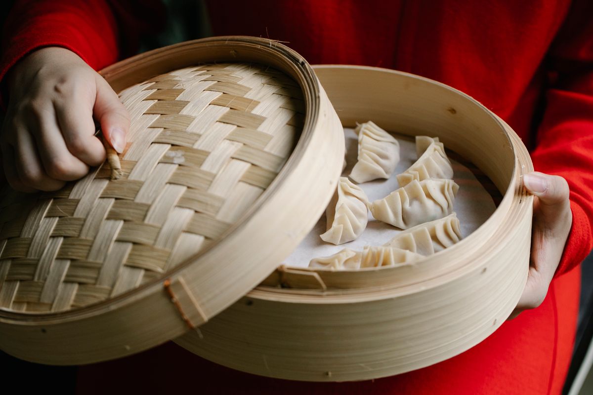 Steamed dumplings presented in a bamboo basket