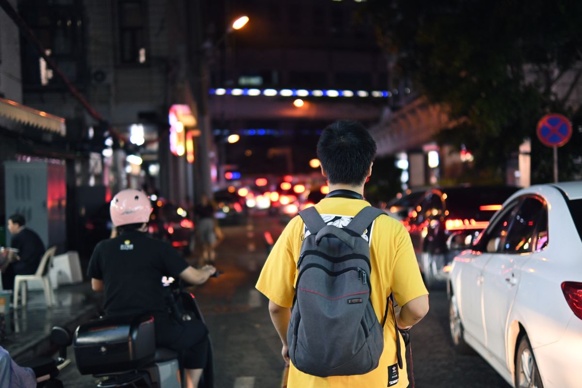 A traveler walking through a Chinese city at night