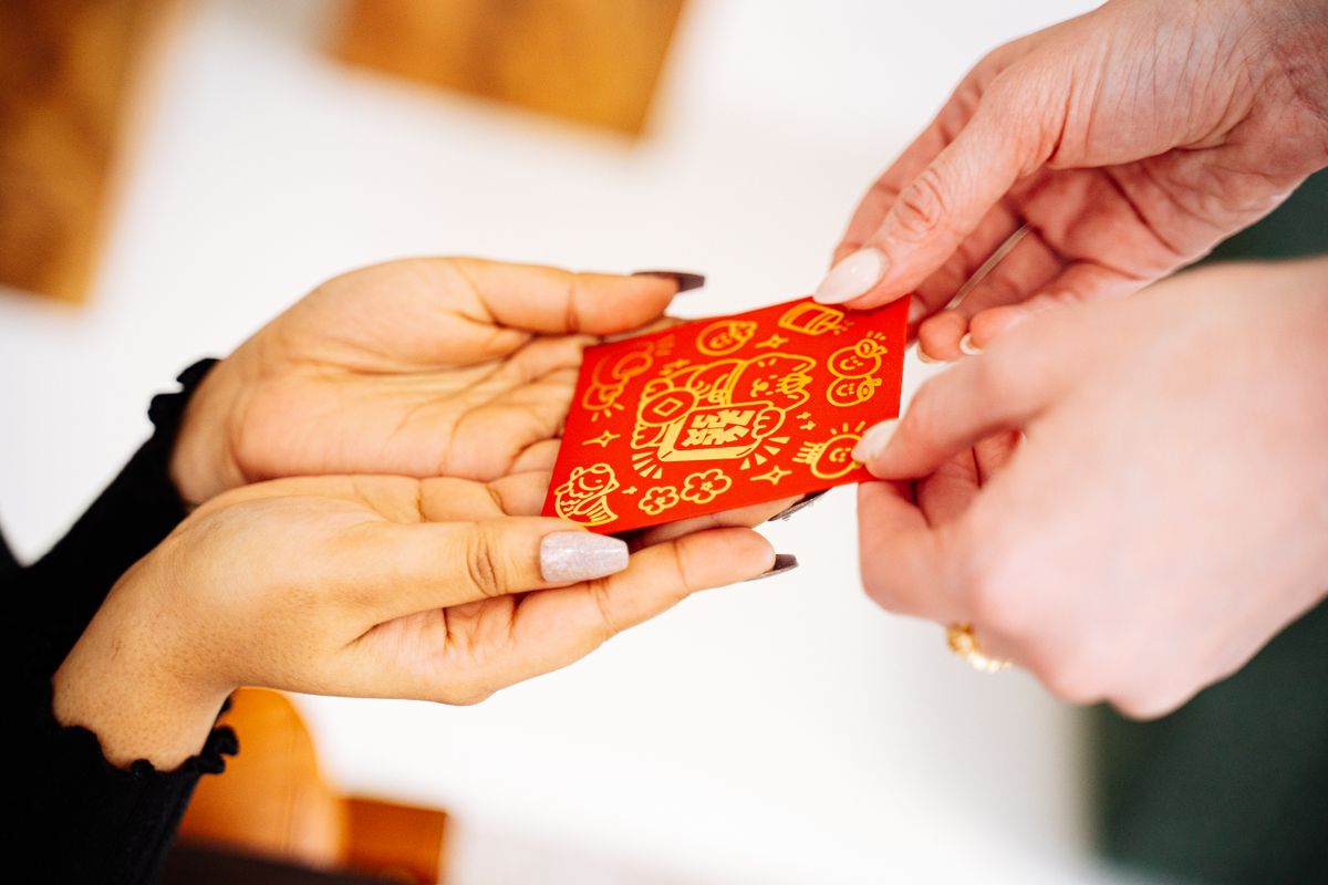 Hands exchanging a red envelope