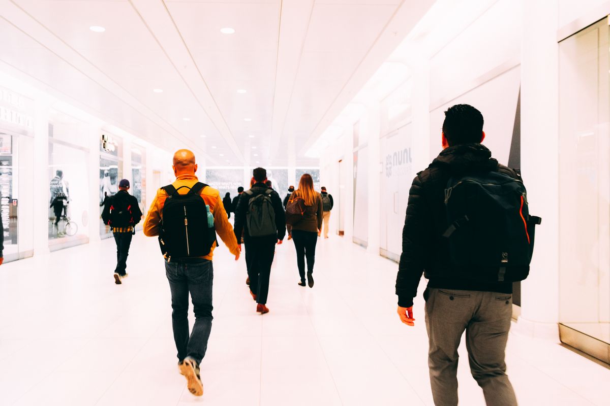 Travelers walking through a bright terminal corridor