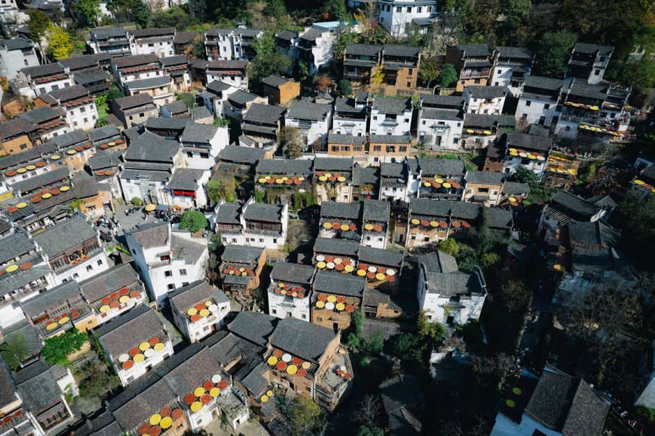 Aerial view of Huangling Village in China showcasing traditional rooftops and vibrant autumn colors.