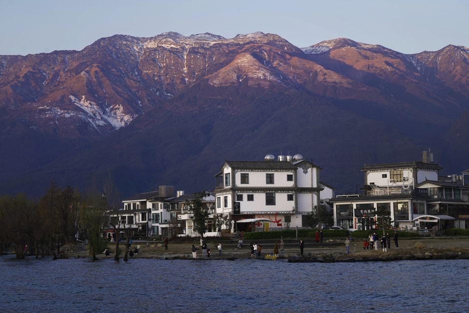 Beautiful village by mountains with traditional Chinese architecture and scenic views.