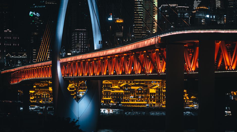 Discover the stunning night view of Qiansimen Bridge, beautifully lit against the Chongqing skyline.