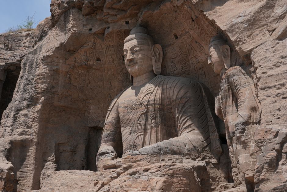 Ancient stone Buddha statues carved into the cliffs at Yungang Grottoes in Datong, China.