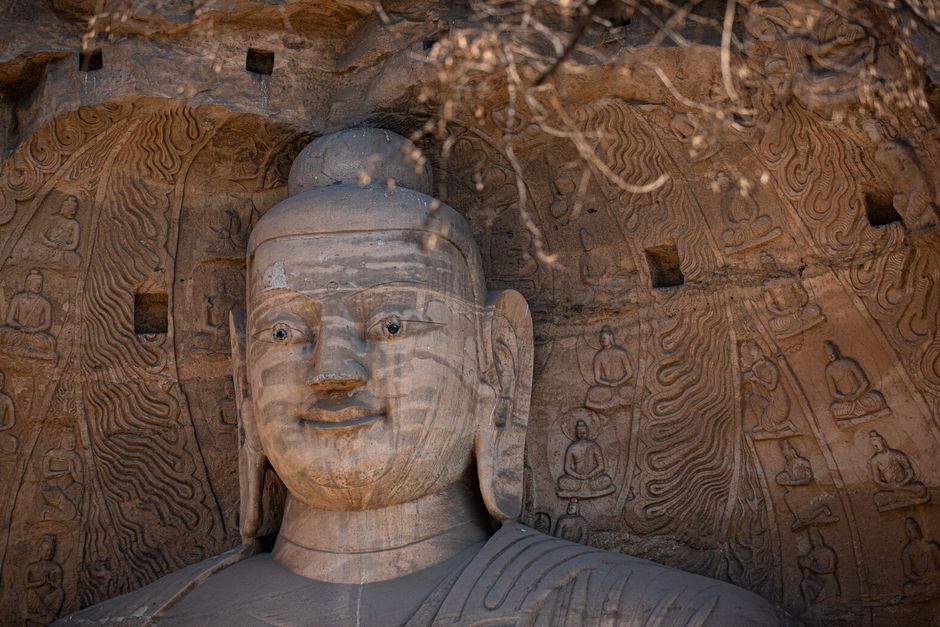 Majestic stone sculpture of Buddha at Yungang Grottoes, showcasing ancient Chinese artistry.