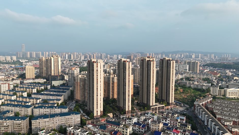 Aerial view of Changsha city with tall residential buildings under clear blue skies.