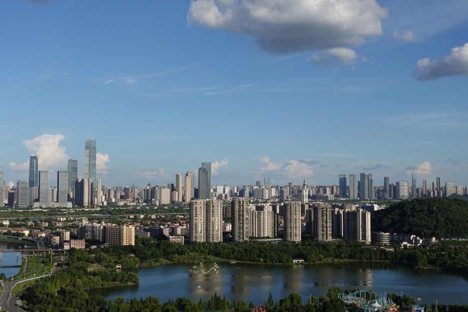 A stunning skyline view showcasing modern skyscrapers and a lush green park under a clear blue sky.